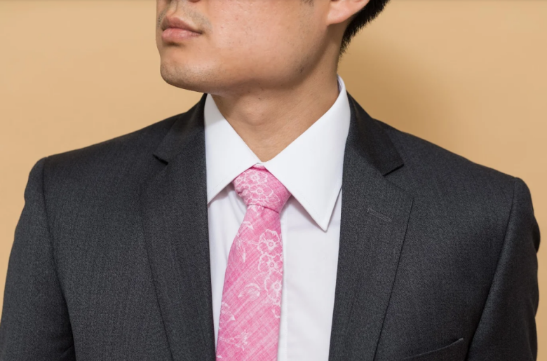 a man with a grey suit, white shirt, and a pink tie