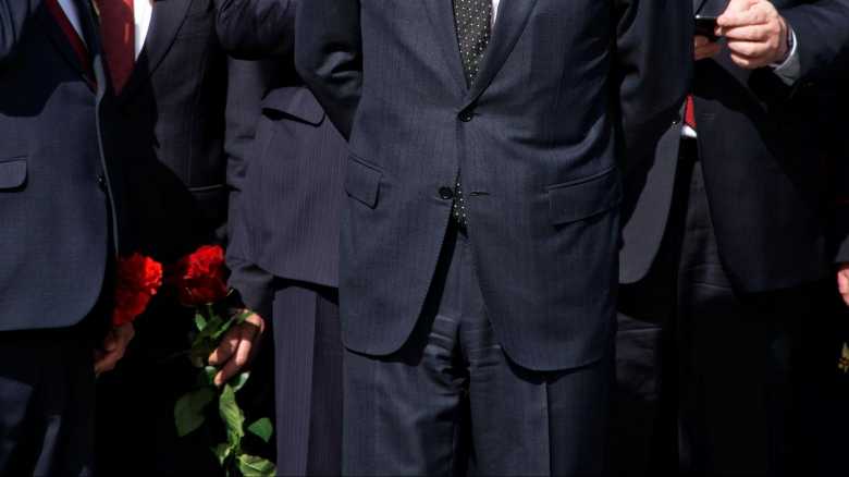 Men in Formalwear Standing holding Red Flowers