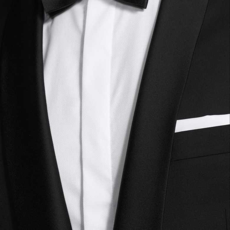 a close-up image of a black suit jacket paired with a white shirt